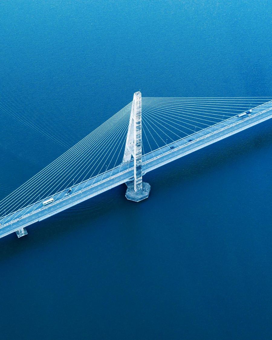 Aerial view of a cable-stayed bridge crossing deep blue water